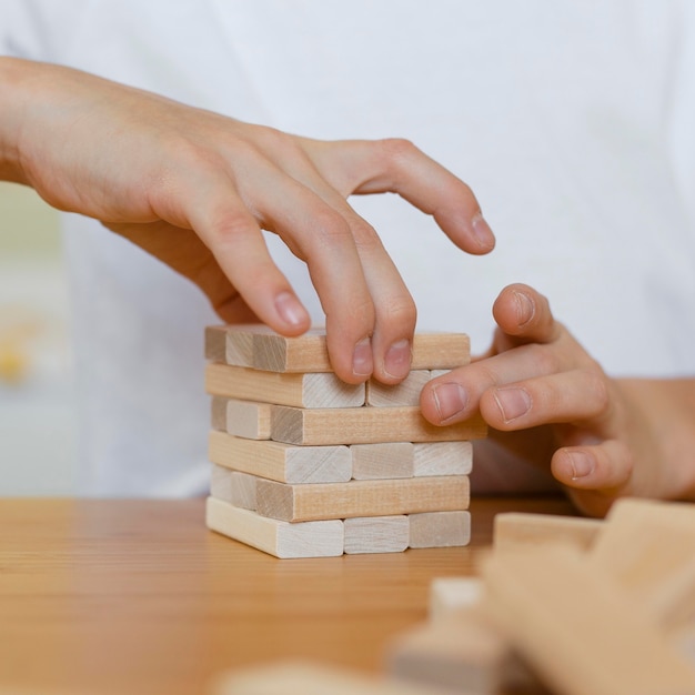 Close-up van jong geitje dat een houten torenspel speelt