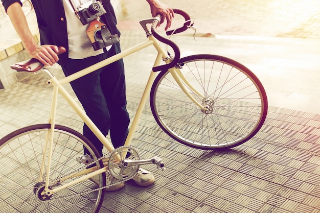 Close-up van jonge man met vintage fiets en camera