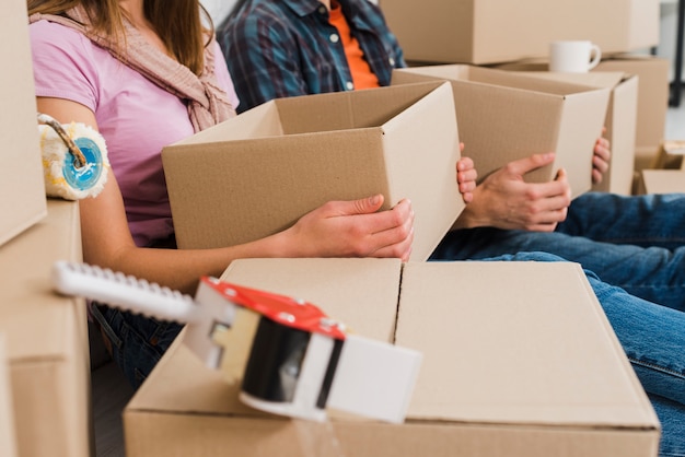 Close-up van jonge paar kartonnen dozen in de hand houden bij hun nieuwe huis