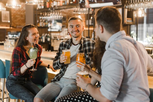 Close-up van jonge vrienden die avond van dranken genieten bij nachtclub