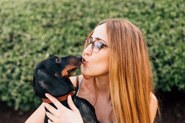 Close-up van jonge vrouw die haar mooie hond kust