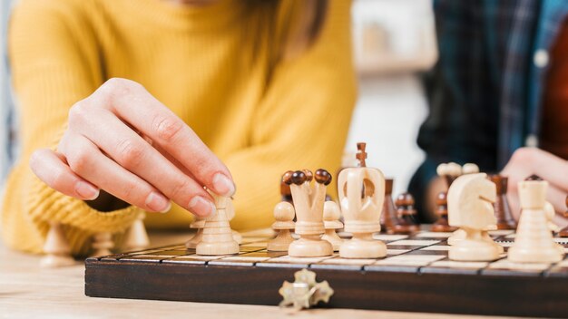 Close-up van jonge vrouw die het spel van de schaakraad speelt