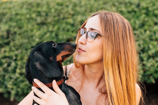 Gratis foto close-up van jonge vrouw die van haar leuke hond houdt