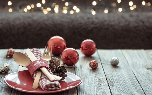 Gratis foto close up van kerst feestelijke tafel instelling op wazig donkere achtergrond met bokeh, kopieer ruimte.