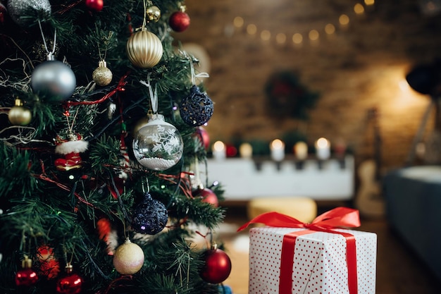 Close-up van kerstboom en ingepakt cadeau thuis