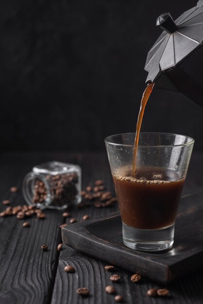 Close-up van koffie in glas wordt gegoten dat