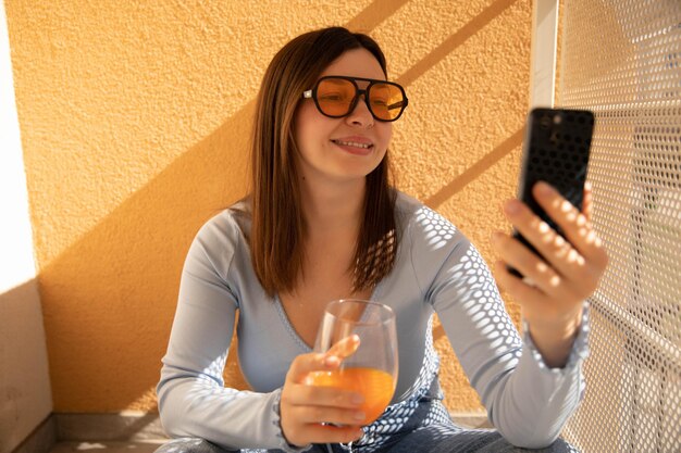 Close-up van lachende vrouw praten aan de telefoon in gele zonnebril