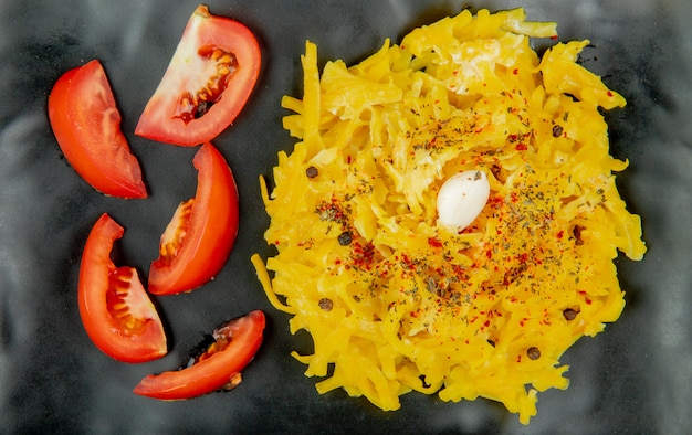 Close-up van macaroni pasta en gesneden tomaat in plaat