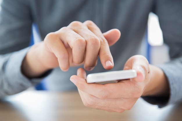 Close-up van mannelijke handen aanraken smartphone screen
