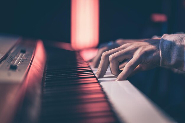 Close-up van mannelijke handen die de pianotoetsen spelen