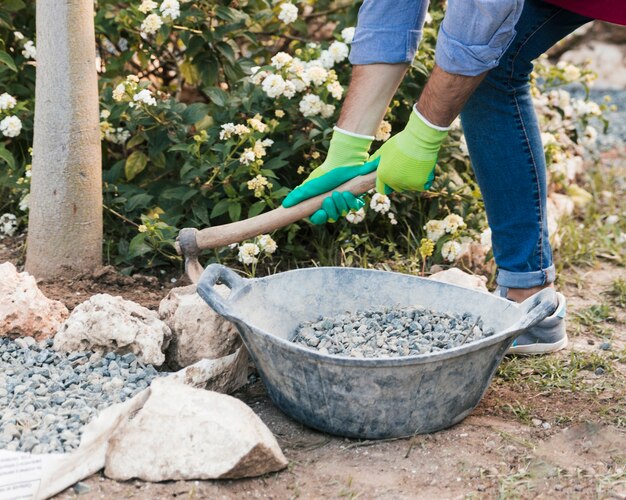 Close-up van mannelijke tuinman die in de tuin werkt