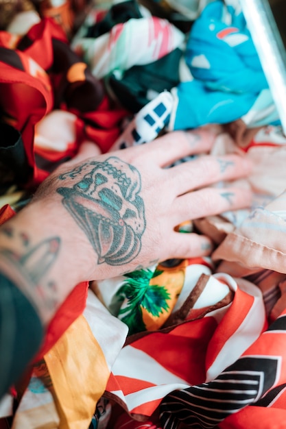 Close-up van mannenhand met tatoeage wat betreft sjaal in winkel