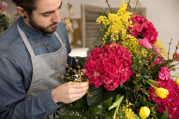 Close-up van mannetje dat de bloemen in het boeket schikt