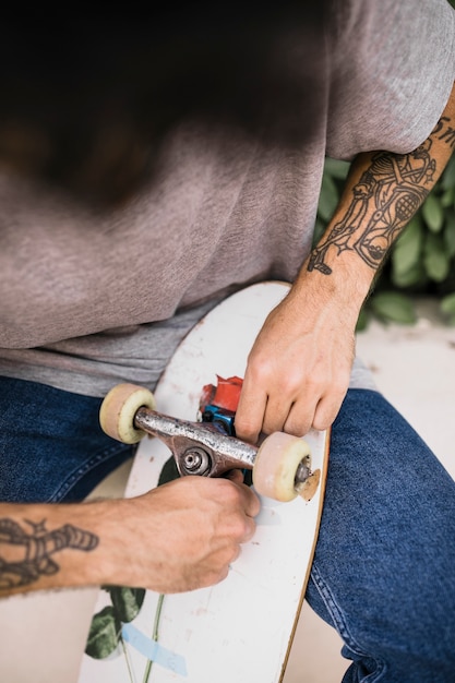 Close-up van menselijke handen die skateboardswiel aanpassen