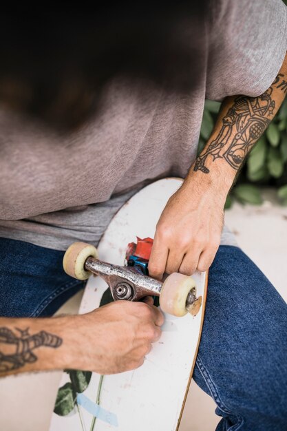 Close-up van menselijke handen die skateboardswiel aanpassen