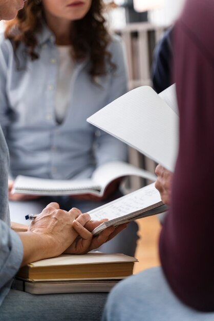 Close-up van mensen die studeren met notitieboekjes