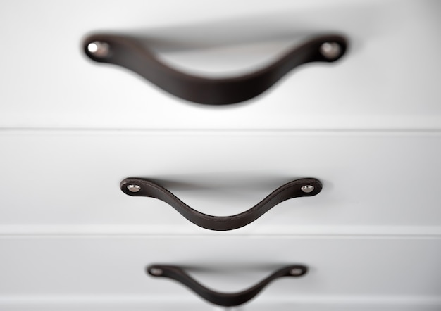 Gratis foto close up van minimalistische witte meubels met zwarte handgrepen, keukenkast, details.