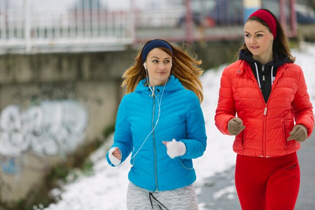 Close-up van mooie twee vrouwelijke atleet die in de winter loopt