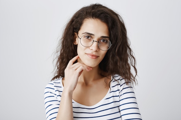 Close-up van mooie vrouw die in glazen met belangstelling kijkt