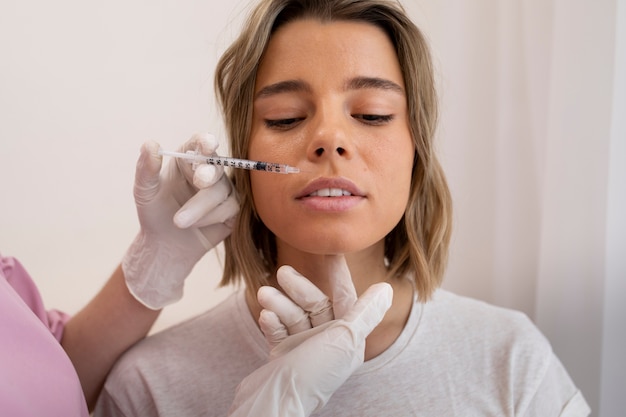 Close-up van mooie vrouw die lipvuller krijgt