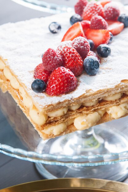 Close-up van Napoleon-cake met vlaroom en rijpe bessen