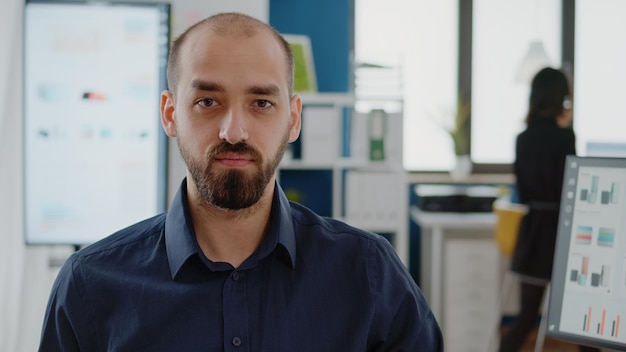 Close up van ondernemer met zakelijke baan kijken naar camera in kantoor. portret van een jonge man die zich voorbereidt om te werken aan de planning voor de ontwikkelingsindustrie met technologie en computer