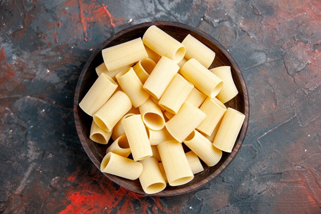 Close-up van ongekookte pasta's in de pot op zwarte tafel