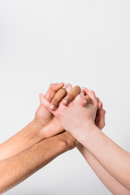 Close-up van paar die tussen verschillende rassen elkaars hand houden tegen witte achtergrond