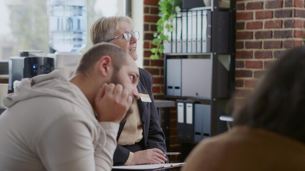 Close-up van psycholoog die advies en begeleiding geeft aan mensen met een verslaving tijdens een vergadering. Vrouw praat met patiënten over herstel en psychische problemen in cirkel tijdens sessie.