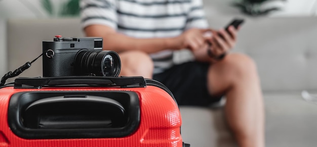 Close-up van Retro camera op bagage met reiziger man zittend op de Bank achtergrond Jonge man heeft zijn bagage ingepakt en is klaar om te gaan reizen vakantie en vakantie concept