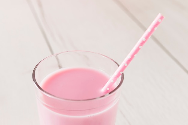 Close-up van roze milkshake in glas met stro