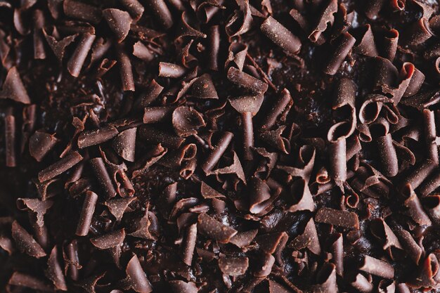 Close-up van smakelijke chocoladetaart met stukjes chocolade op bakplaat. Detailopname.