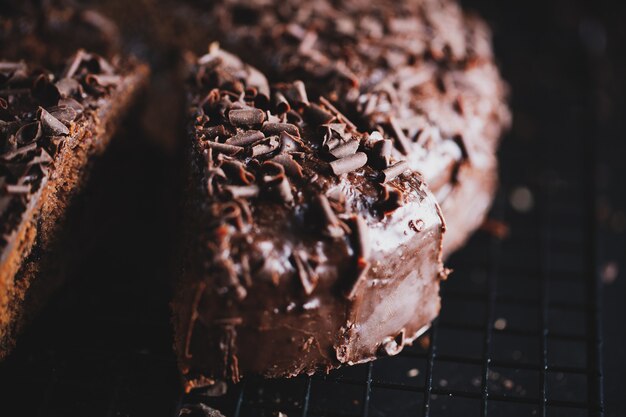 Close-up van smakelijke chocoladetaart met stukjes chocolade op bakplaat.