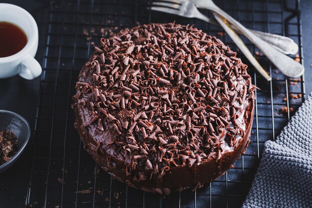 Close-up van smakelijke chocoladetaart met stukjes chocolade op bakplaat.