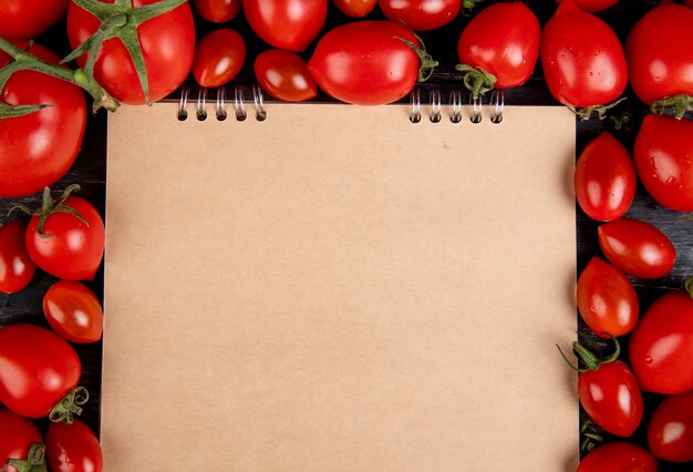 Close-up van tomaten rond notitieblok op houten tafel met kopie ruimte