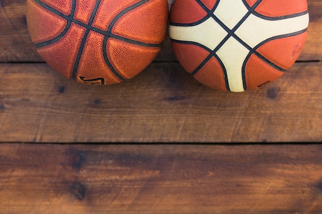 Gratis foto close-up van twee verschillende soorten basketbal op houten tafel