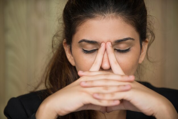 Close-up van vermoeide jonge vrouw wrijven neus