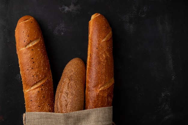 Close-up van verschillende soorten stokbrood aan de linkerkant en zwarte achtergrond met kopie ruimte