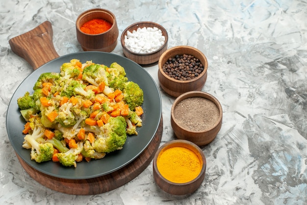 Close-up van verse en gezonde groentesalade op houten snijplank op witte tafel