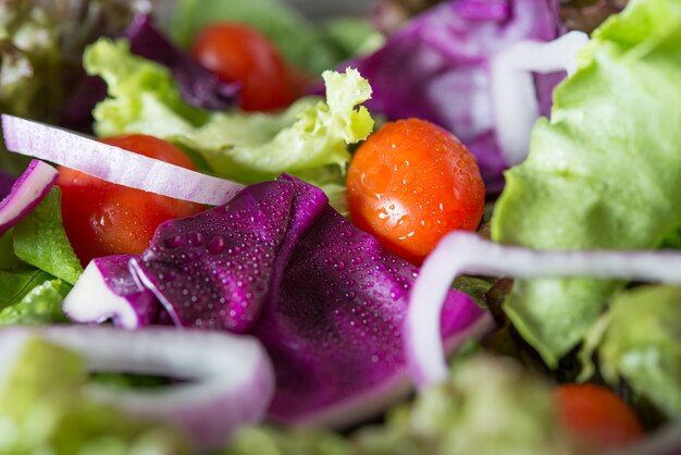 Close-up van verse groentesalade in de kom met rustieke oude houten achtergrond. Gezond eten concept.