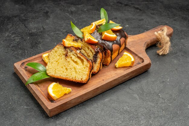 Close-up van versgebakken zachte cake plakjes op houten snijplank op donkere tafel