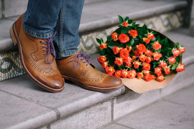 Close-up van vintage schoenen met paarse veters en een boeket rozen