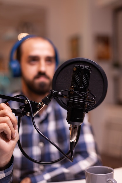 Close-up van vlogger die microfoon vasthoudt terwijl hij spreekt tijdens online interview