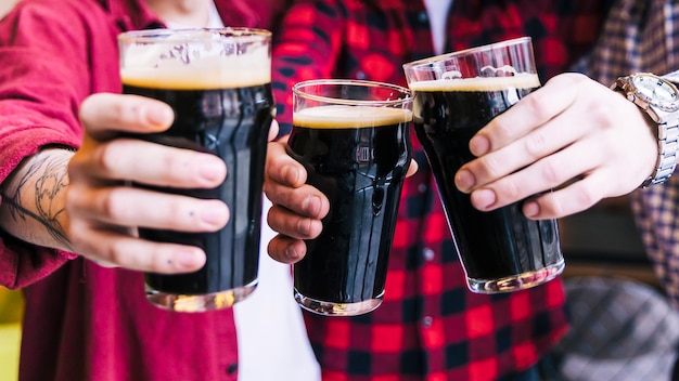 Gratis foto close-up van vrienden die de bierglazen rammelen