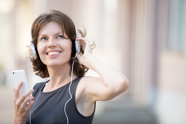 Close-up van vrolijke vrouw luisteren naar muziek