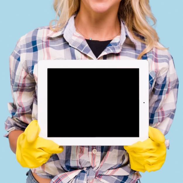 Close-up van vrouw die gele handschoenen draagt die lege het scherm digitale tablet houden