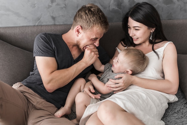 Close-up van vrouw die haar echtgenoot bekijkt die de hand van zijn zoon bijt