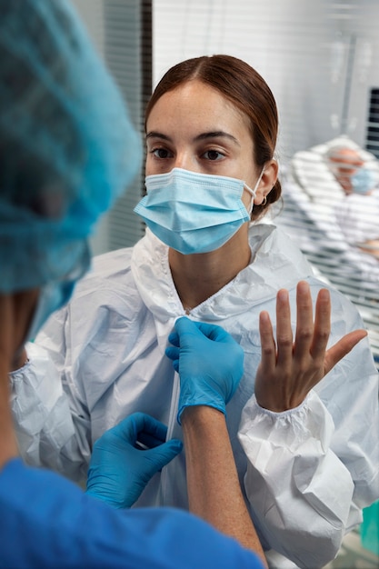 Close-up van vrouw die hazmat-pak en masker draagt