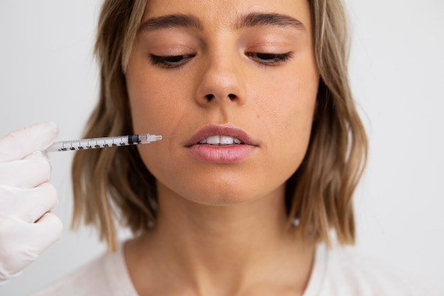Gratis foto close-up van vrouw die lipvuller krijgt