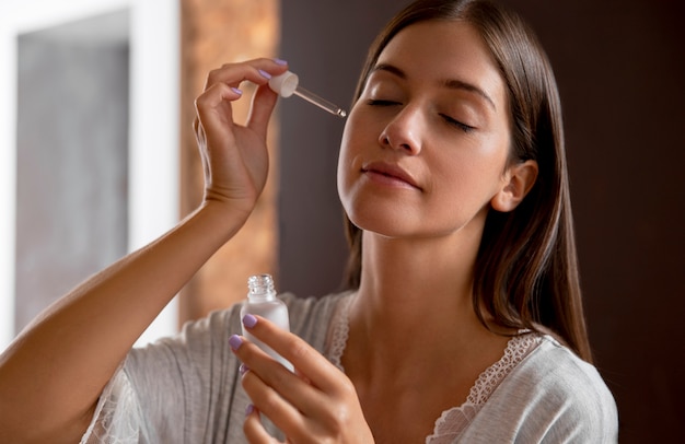 Close-up van vrouw die serum aanbrengt